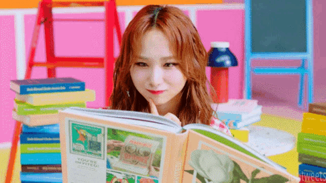 a young woman is reading a book titled you 're invited