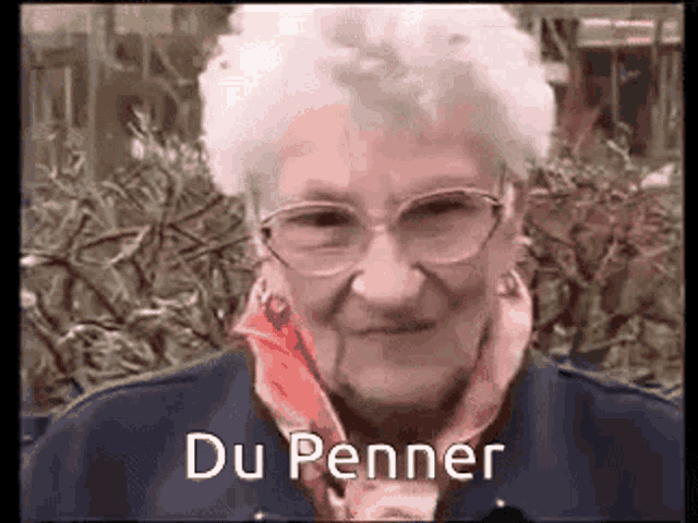 a close up of an elderly woman wearing glasses and a scarf with the words du penner written on it .