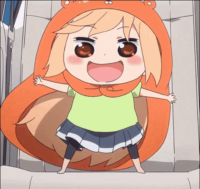 a girl in a green shirt and orange hooded blanket is standing with her arms outstretched