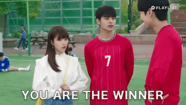 a girl in a white shirt is standing next to a boy in a red jersey with the number 7 on it