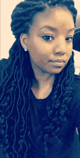 a woman with dreadlocks is taking a picture of herself