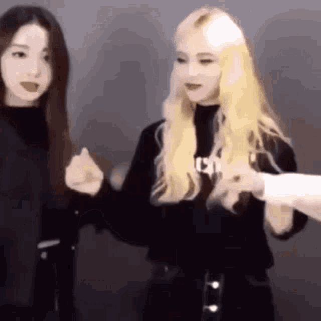 two women are holding hands and talking to each other .
