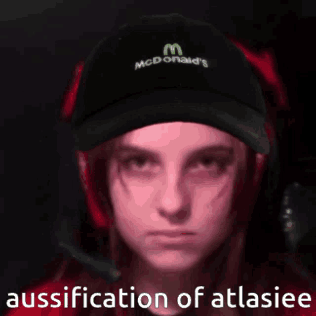 a woman wearing a maccas hat and headphones looks at the camera