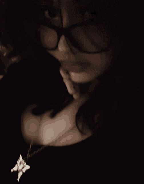 a woman wearing glasses and a star necklace