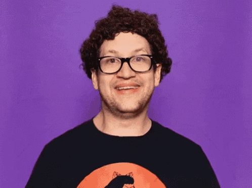 a man with curly hair and glasses is giving a thumbs up on a purple background