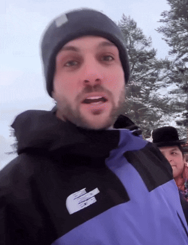 a man wearing a black beanie and a purple jacket with the letter e on the side