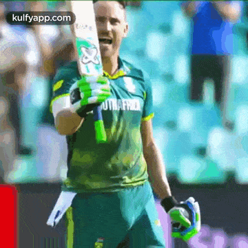 a cricket player is holding a bat in his hand and smiling while wearing a south africa jersey .