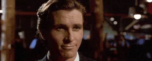 a man in a suit and tie is smiling and looking at the camera