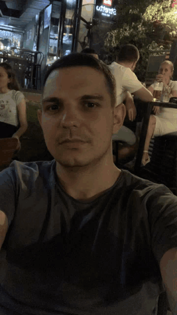 a man is taking a selfie in front of a sign that says ' coca cola ' on it