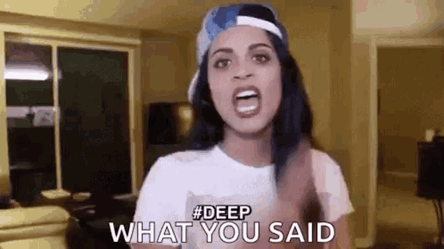 a woman wearing a baseball cap and a white t-shirt is screaming .