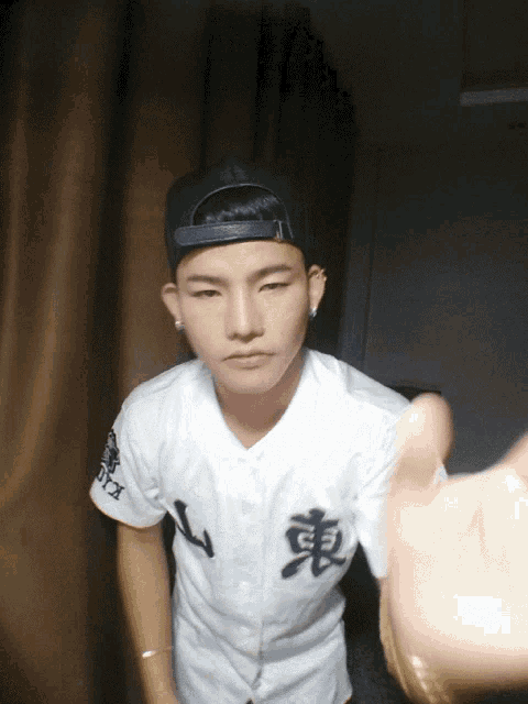 a young man wearing a baseball uniform with chinese characters on it