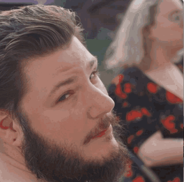 a man with a beard is looking to the side