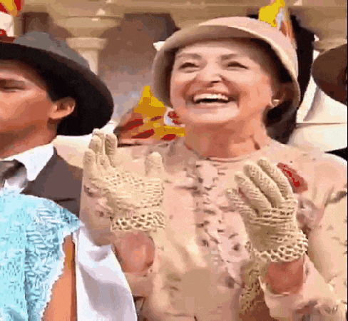 a woman wearing a hat and gloves is laughing and waving her hands