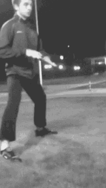 a black and white photo of a man walking on a sidewalk