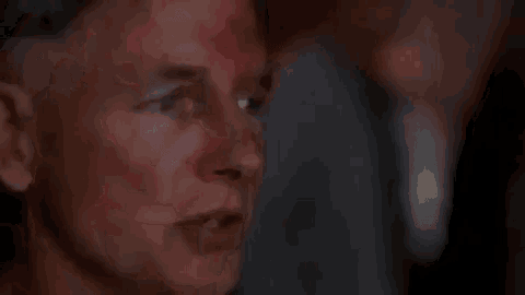a close up of a man 's face with blood on it and a blurry background .