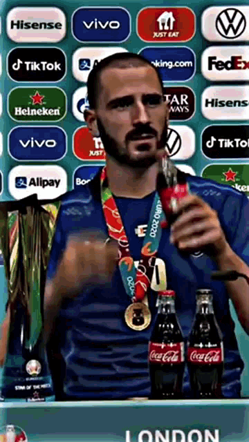 a man with a medal around his neck holding a coca cola bottle