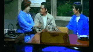 a group of people are sitting around a table with a box on it .