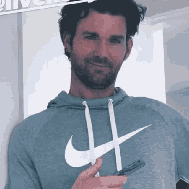 a man with a beard wearing a nike hoodie