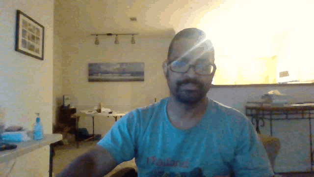 a man wearing glasses and a blue shirt with the word thailand on it