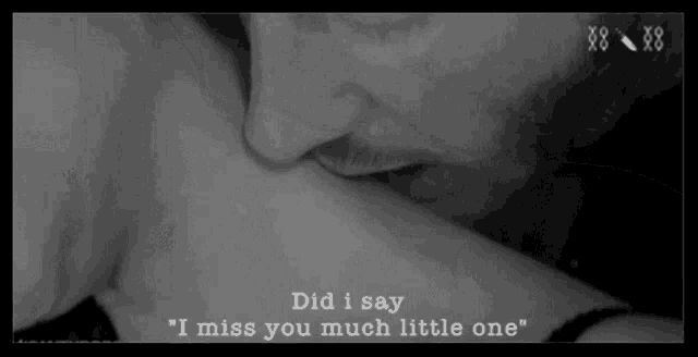 a black and white photo of a man kissing a woman on the neck
