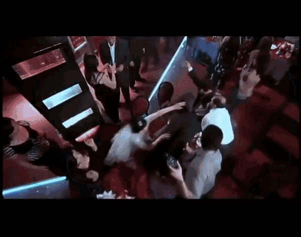 a group of people are dancing in a dark room with red white and blue stripes