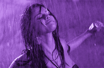 a woman in a bikini is dancing in the rain
