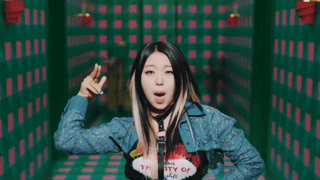 a woman in a blue jacket is giving the middle finger to the camera