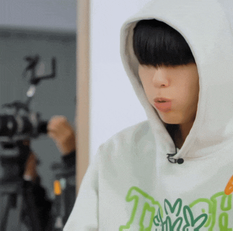 a close up of a person wearing a hoodie with a camera in the background .