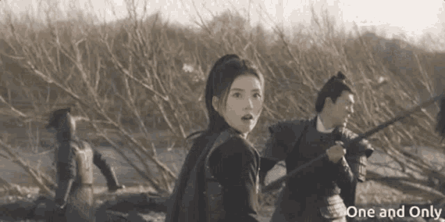 a woman is standing in front of a group of people holding swords in a scene from rakuten viki .