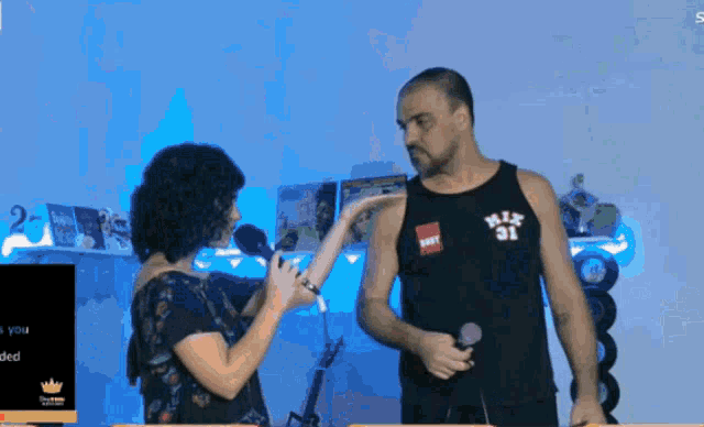 a man singing into a microphone while a woman holds a microphone
