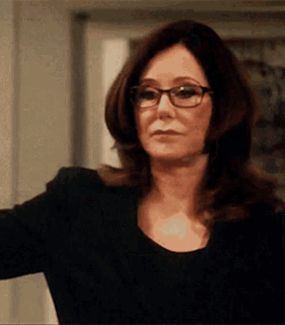 the woman is wearing glasses and a black shirt .