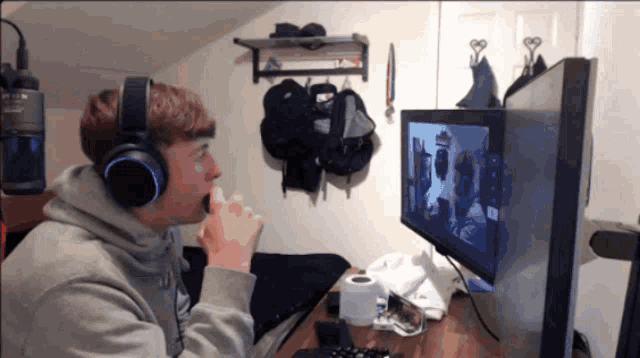 a man wearing headphones is sitting in front of a computer monitor