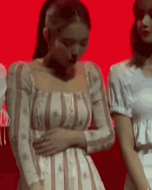 a woman in a striped dress is standing next to another woman .