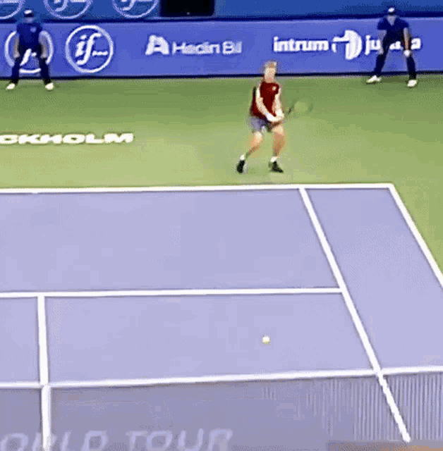 a man is playing tennis on a court with an advertisement for intrum