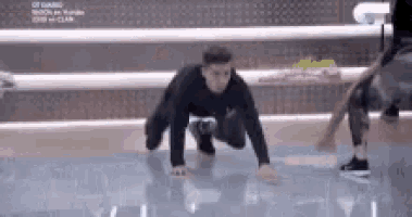 a man in a black shirt is doing a handstand on the floor