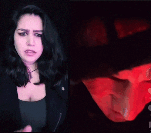 a woman in a black jacket stands next to a red object
