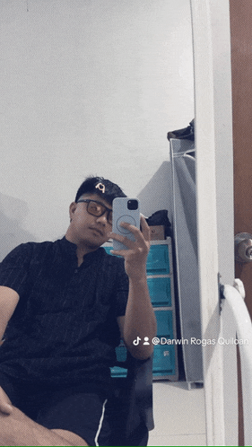 a man is taking a selfie in front of a mirror with darwin rogas written below him