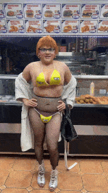 a woman in a bikini is standing in front of a display of food