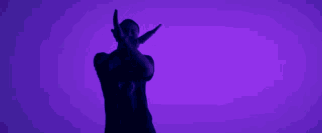 a man in a black shirt is standing in front of a purple background