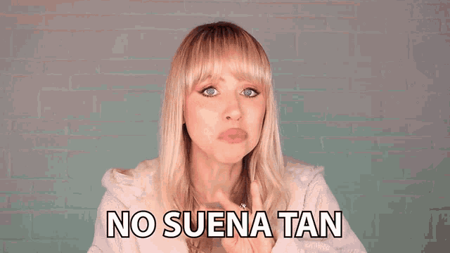 a woman says no suena tan in front of a white brick wall