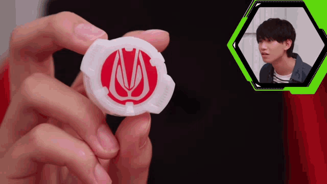 a person is holding a white object with a red circle on it
