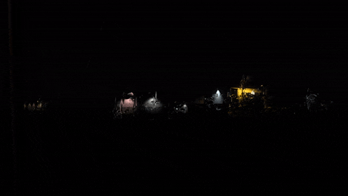 a group of people are gathered in the dark in front of a church