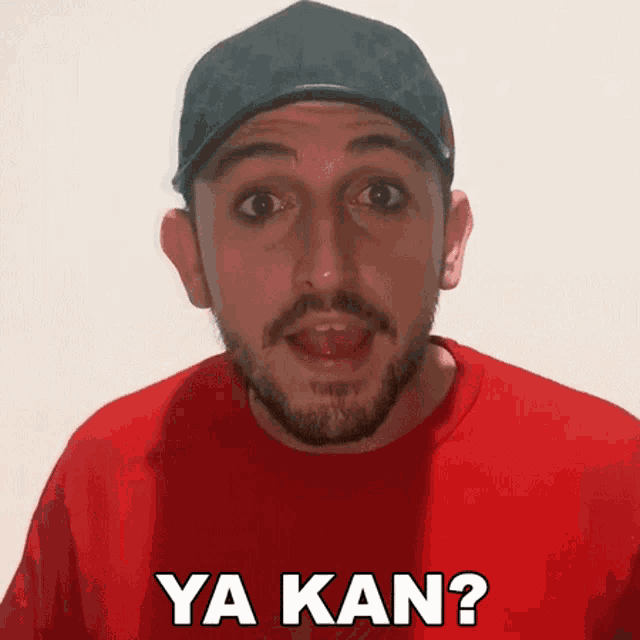 a man with a beard is wearing a red shirt that says ya kan on it
