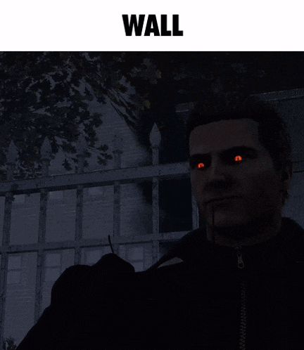 a man in a black coat is standing in front of a fence with the word wall above him