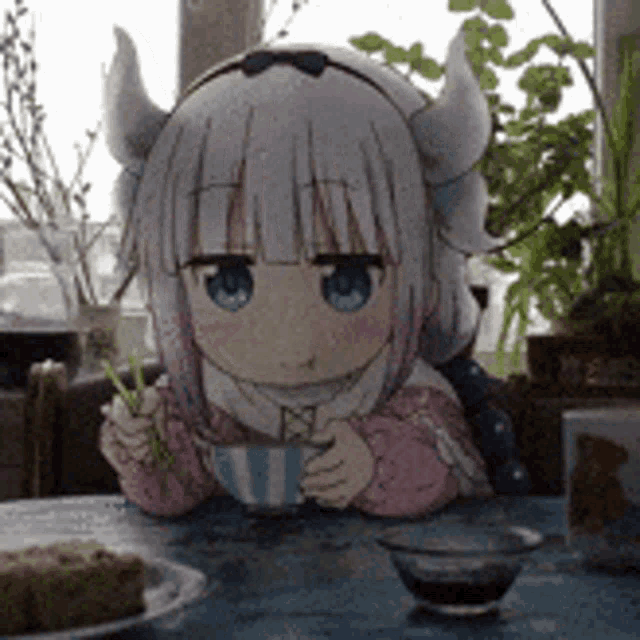 a cartoon girl with horns is sitting at a table eating food .