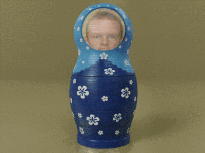 a blue green and orange russian nesting doll with a man 's face on it
