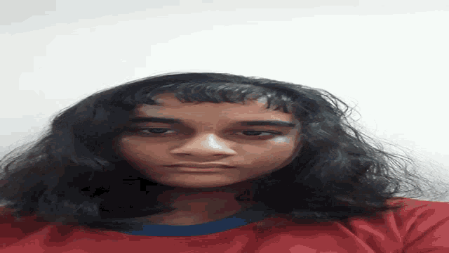 a woman with long dark hair is wearing a red shirt and a blue collar