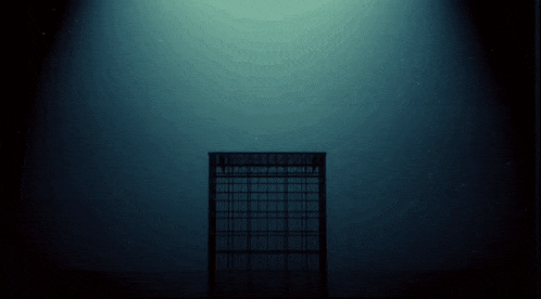 a dark room with a light shining on a building that says ' i ' on it