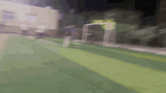 a blurry picture of a soccer field with a goal and a building in the background