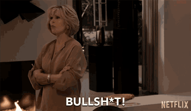 a woman stands in front of a fireplace and says " bullshit "